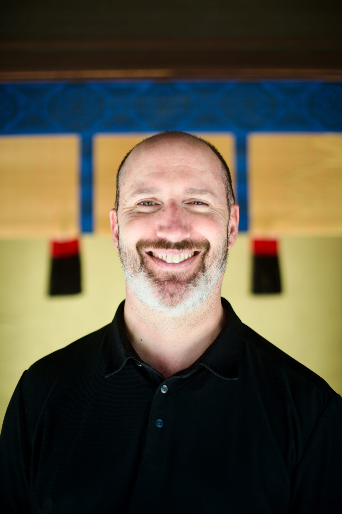 A smiling man photographed at the shrine gate